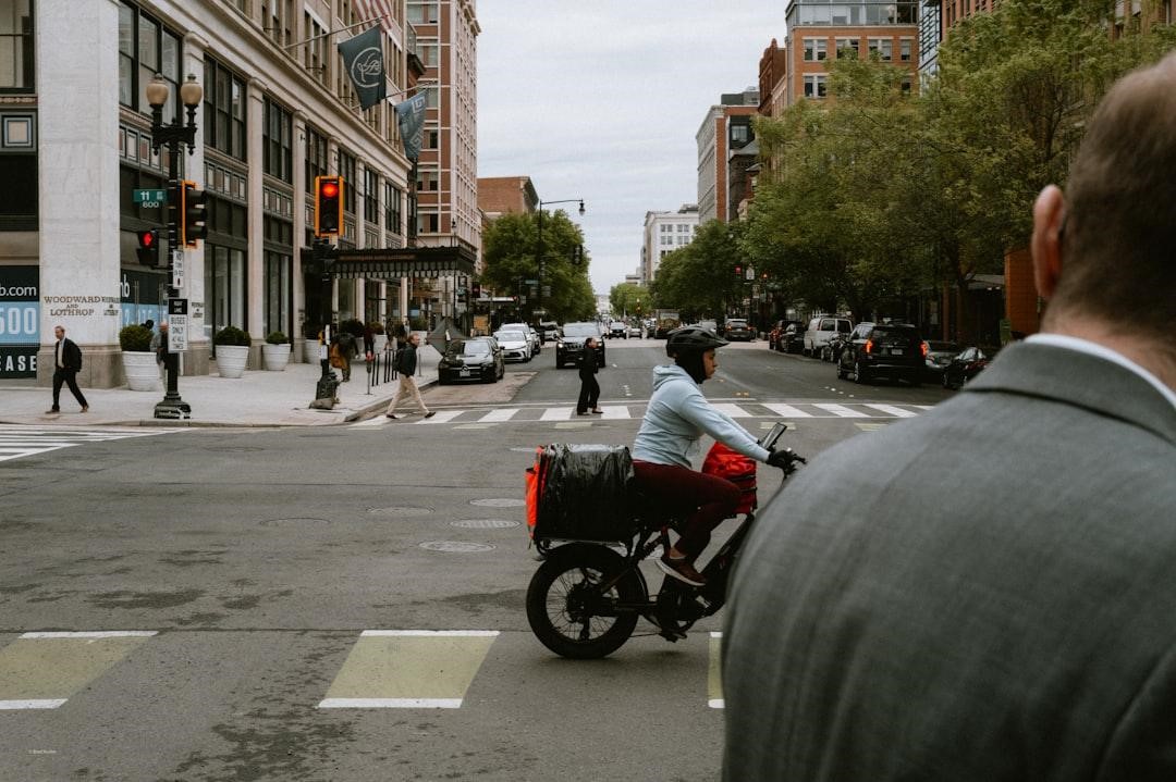 Person commuting on an electric bike along an urban street with bike lane markings